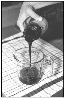 Molasses Water combines thick, sweet molasses, shown here being poured into a measuring cup, with lemon juice and water. Molasses Water is similar to lemonade, sweetened with the distinctive molasses flavor. EPD Photos