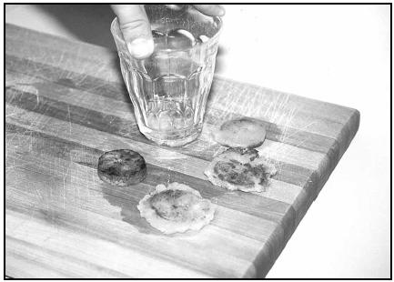 Use a flat spatula or the bottom of a drinking glass to flatten the fried plantain slices to make Bannann Peze. EPD Photos