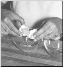 To separate the eggs for Bolo Polana (Cashew Nut and Potato Cake), transfer the egg yolk back and forth between the two eggshell halves, letting the white drip into the bowl. EPD Photos