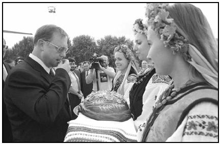 A visiting politician is greeted with the traditional Ukrainian welcome of bread, representing hospitality, and salt, representing friendship. The specially decorated loaf of bread and the salt are offered by young women dressed in folk costume. AP Photo/Richard Drew